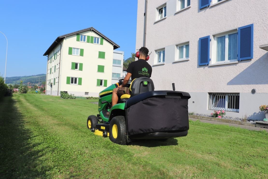 Gärtner mit Sitzrasenmäher